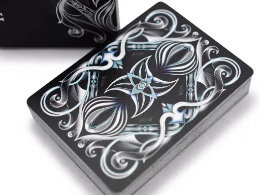 Part of the 4-deck Seasons series, the Inverno Deck embodies Winter. The back design makes use of metallic gold and blue accents, as well as intricate flourishing, to render an abstract representation of winter and