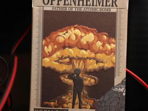 The standard edition of the Oppenheimer Playing Cards is called Radiance and the design intricately weaves the narrative of J. Robert Oppenheimer, renowned as the father of the atomic bomb.The Oppenheimer Radiance Playing Cards has